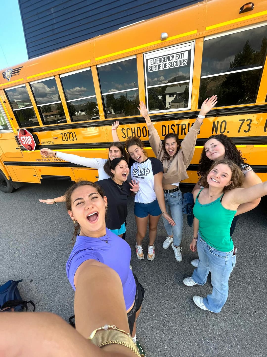 Group of students in front of a school bus during a school year in Canada within the Canadian school programme.