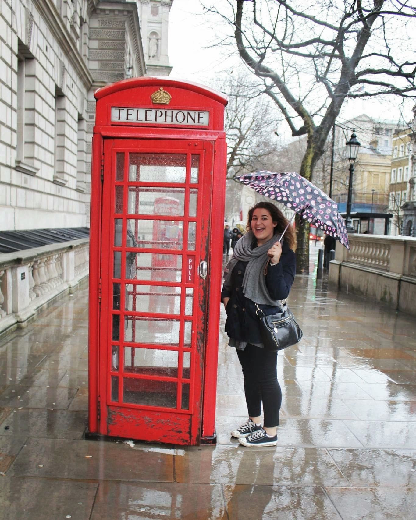 Student standing next to a red telephone box in London, showing everyday life during a school exchange programme in England.
